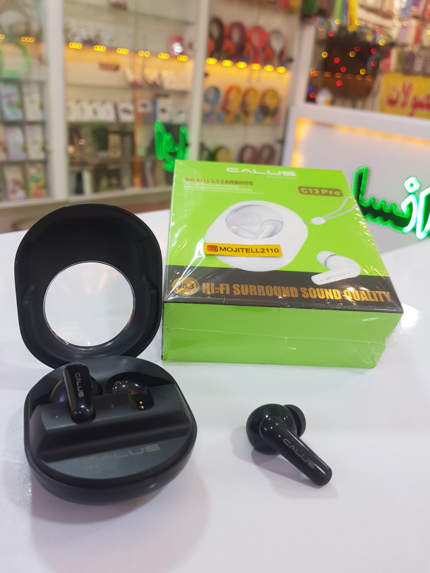 نمای نزدیک از ایرپاد C13 Pro کالوس با کیس گرد و طراحی خاص در فروشگاه مُجیتِل