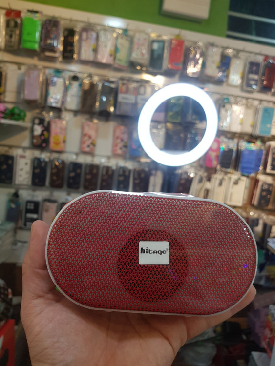 نمای نزدیک از اسپیکر بلوتوثی Hytige CRYSTAL BT-5.0 رنگ زرشکی در دست فروشنده فروشگاه مجیتل