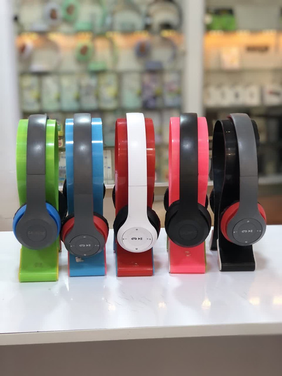 چند هدفون بیسیم JBL مدل P47 در رنگهای مختلف شامل سبز، قرمز و مشکی، به نمایش گذاشته شدهاند.