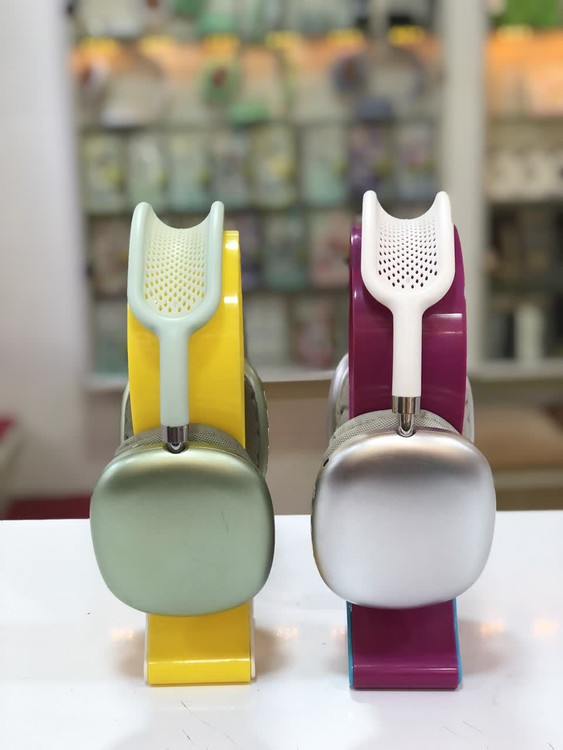 نمای نزدیک از هدفونهای رنگی با طراحی خاص و رنگهای شاد (سبز و سفید) بر روی پایه، با طراحی مدرن و ارگونومیک