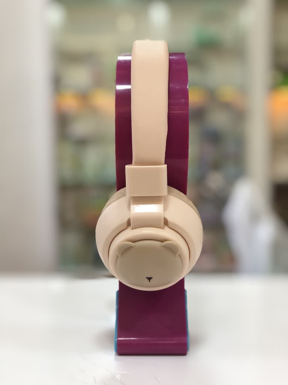 نمای جانبی از هدفون MZ مدل C-1101 با طراحی کودکانه در رنگ کرم و بنفش، قرار گرفته بر روی پایه