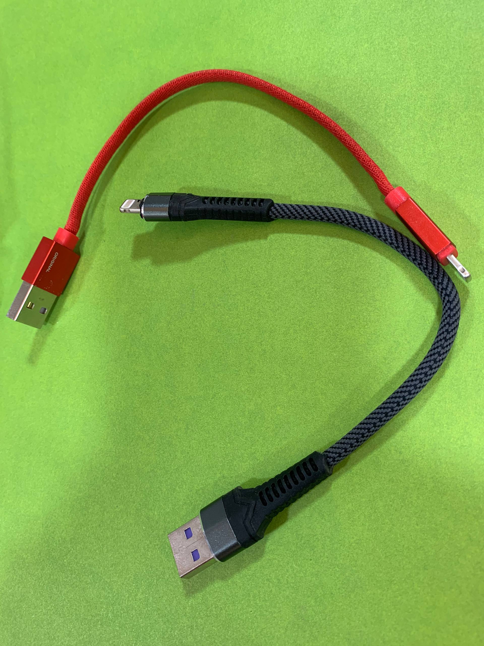 Short red Lightning power bank cable on green background